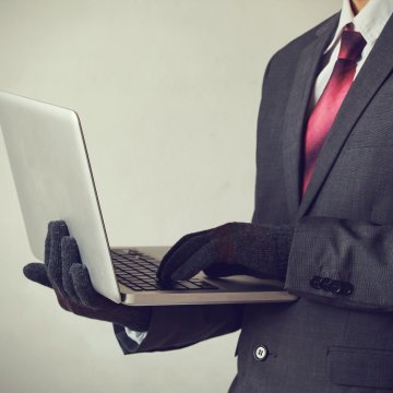 man in suit with gloves on laptop id theft protection services zander